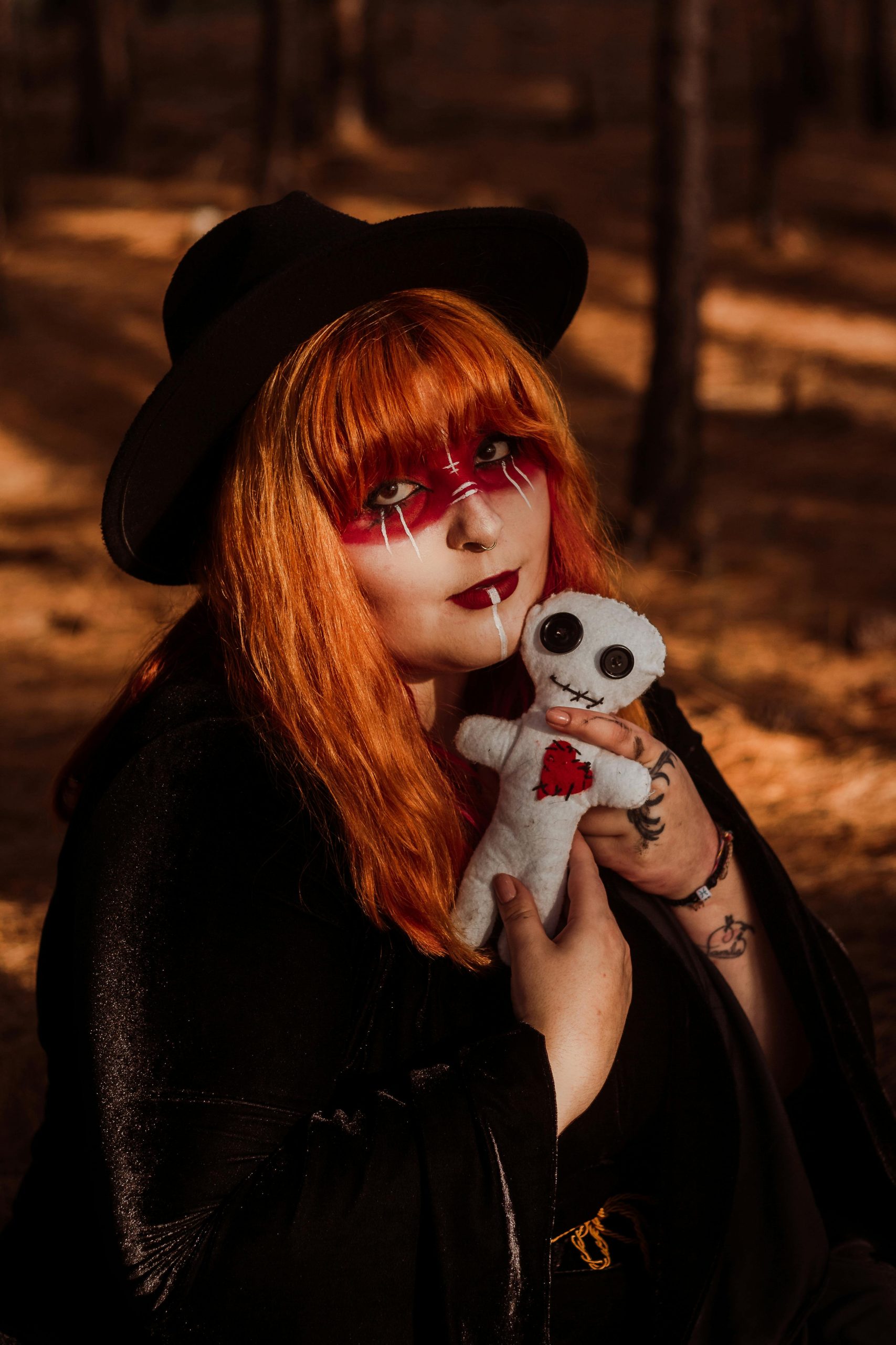 A witch in a forest holding a voodoo doll, evoking a mysterious and eerie atmosphere.